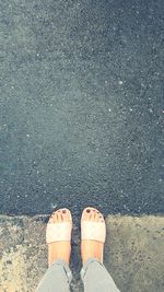 Low section of woman standing on road