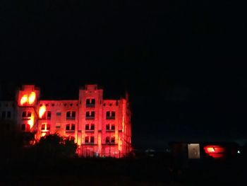 Low angle view of illuminated buildings against sky at night