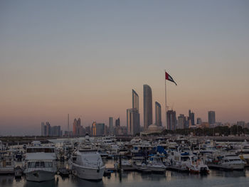 View of buildings at harbor against sky during sunset