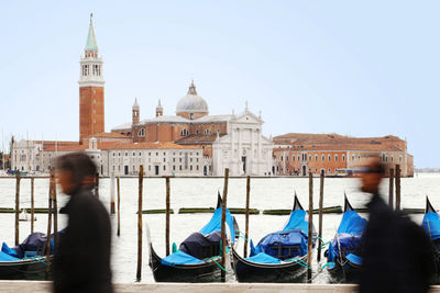 Blurred motion of people by church of san giorgio maggiore against clear sky