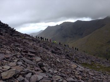 People on mountain against sky