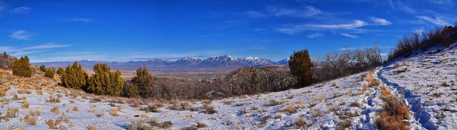 Scenic view of snowcapped mountains against blue sky