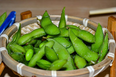 Close-up of green chili peppers in basket on table