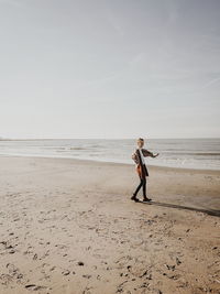 Man standing on beach against sky