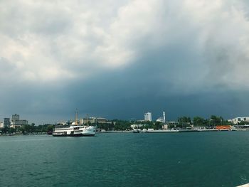 Scenic view of sea by buildings against sky