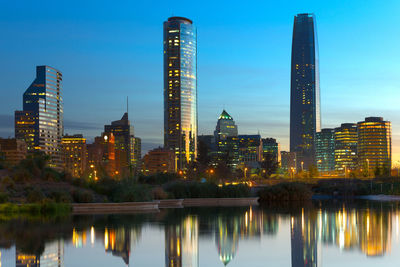 Reflection of illuminated buildings in city at dusk