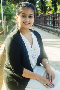 Portrait of smiling woman sitting outdoors