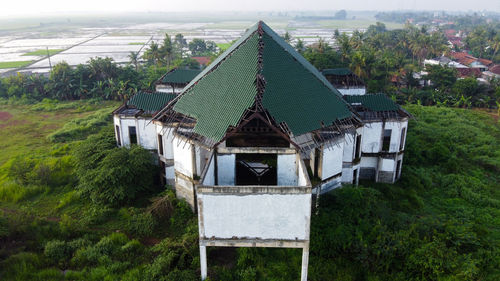 House amidst trees and buildings against sky