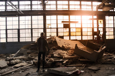 Full length of man standing in abandoned warehouse
