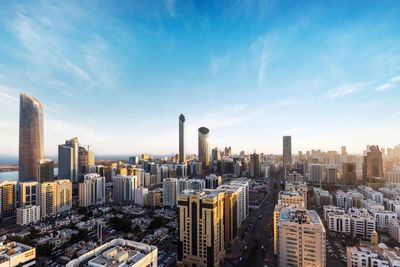 Aerial view of city buildings against cloudy sky