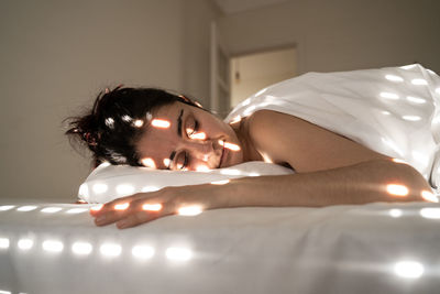 Young woman lying down on bed