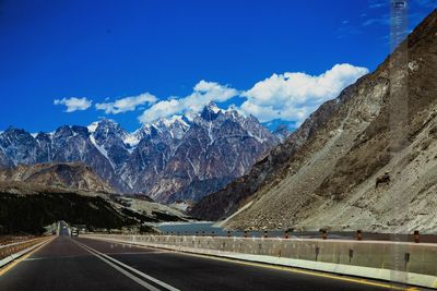 Road leading towards mountains against sky