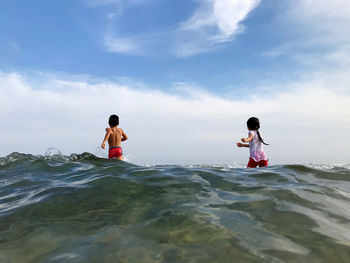 People on sea shore against sky