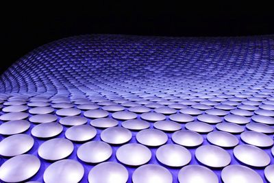 Close-up of illuminated lighting equipment against black background