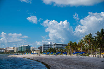 Scenic view of beach by buildings against sky