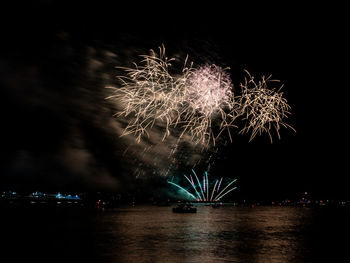 Firework display over river at night
