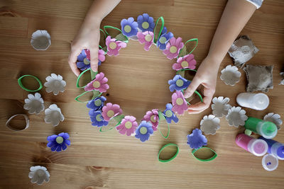 Cropped hand of woman holding christmas decorations on table