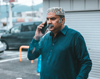 Man holding camera while standing by car