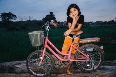 Portrait of woman with bicycle against plants