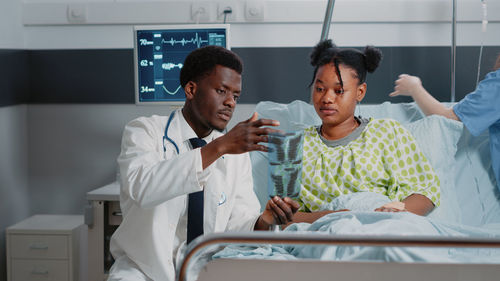 Doctor showing medical x-ray to patient at hospital