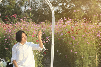 Woman standing by flowering plants