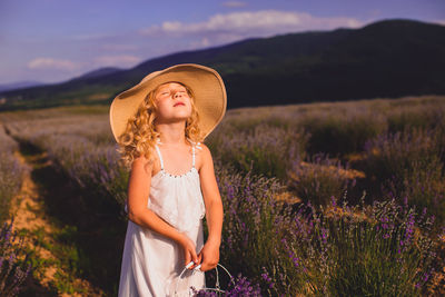 Woman wearing hat standing on field