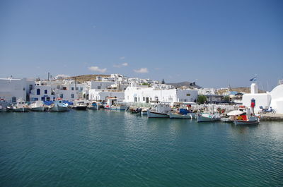 View of town by sea against clear blue sky