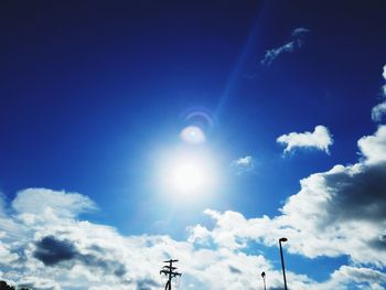 Low angle view of sun shining in blue sky