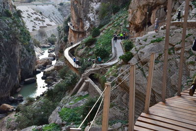 Footbridge over rocks against mountains