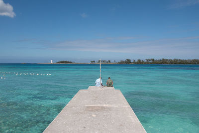 Pier over sea against blue sky