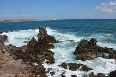 Scenic view of rocks in sea against sky