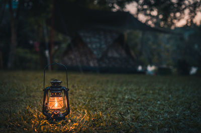 Illuminated oil lamp on field at night