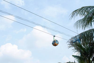 Low angle view of overhead cable cars against sky