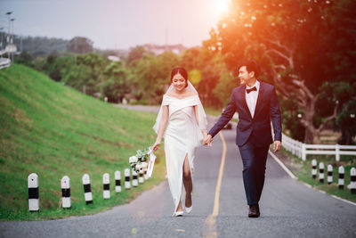 Married couple walking on road in park