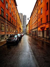 Surface level of wet road against buildings in city