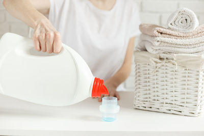 Midsection of woman holding basket at home