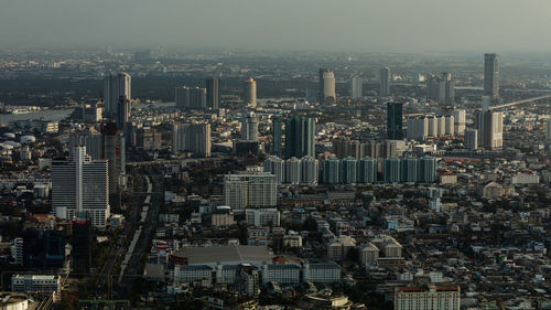 Aerial view of buildings in city against sky