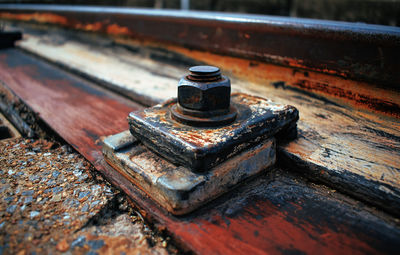 Close-up of rustic bolt and the old abandoned railroad track