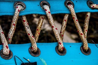 Close-up of rope tied up of blue swing