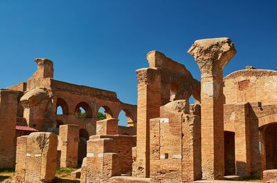 Low angle view of old ruins against blue sky