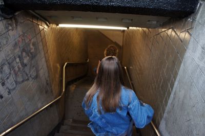 Rear view of woman standing against wall