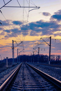Railroad tracks against sky during sunset