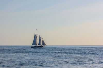 Sailboat sailing on sea against clear sky