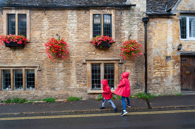 Full length of kids playing on road against houses