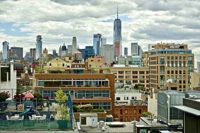 Buildings in city against cloudy sky