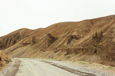 Road amidst desert against clear sky