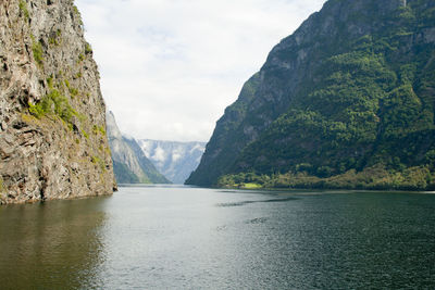 Scenic view of river amidst mountains against sky