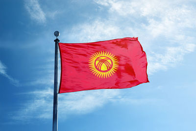 Low angle view of flag against blue sky