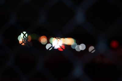 Defocused image of lights against sky at night