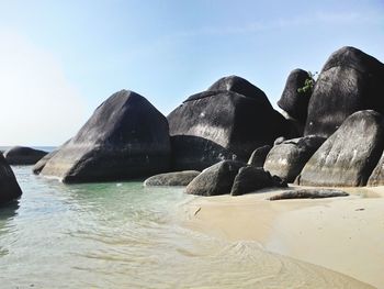 Rocks on beach against sky